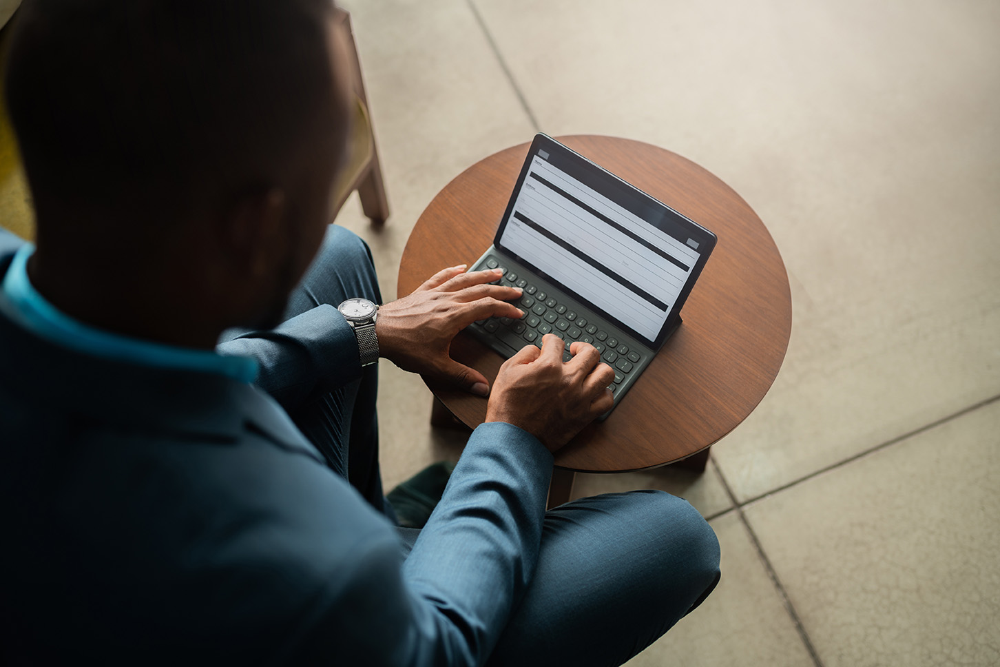 Laptop is placed on the table and a man is working on laptop