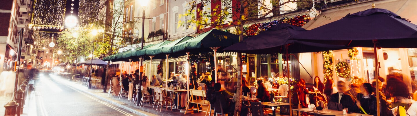 Street filled with customers sat outside dining restaurants